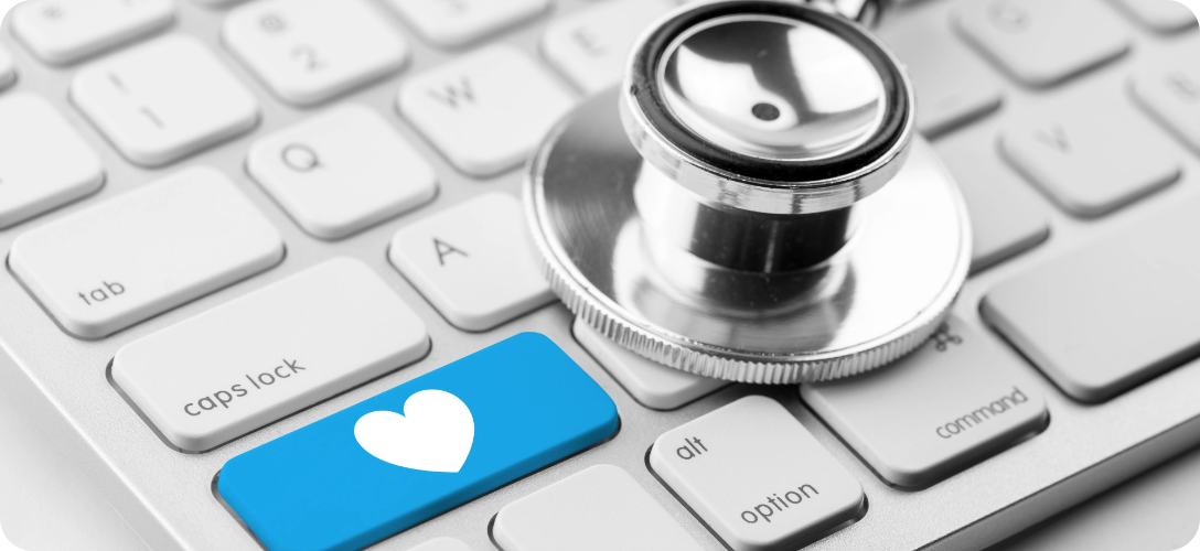 Estetoscópio sobre teclado com tecla azul e coração